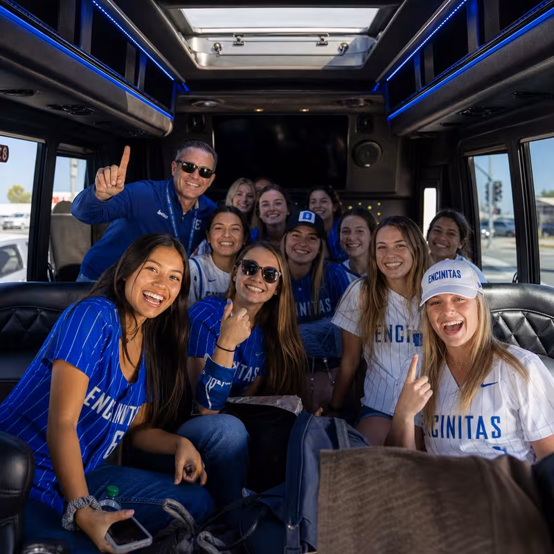 Group boarding a white charter bus for Sporting Event Transportation transportation in Encinitas
