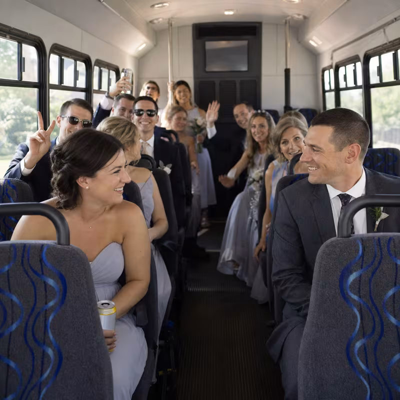 Group boarding a white charter bus for Wedding Transportation transportation in Encinitas